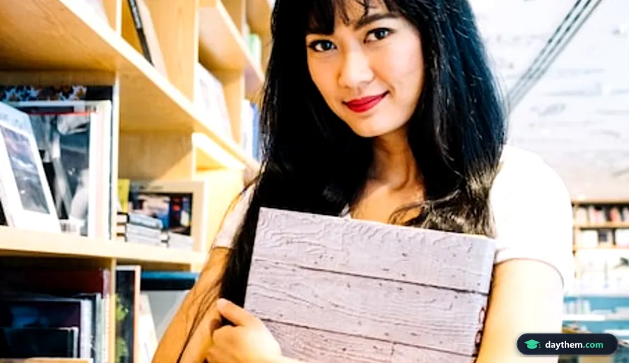 Học viên cầm sổ ghi chép trong thư viện khi tìm kiếm tài liệu học từ vựng IELTS