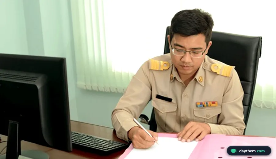 Nhân viên nam mặc trang phục công sở hành chính chuyên nghiệp đứng làm việc trong văn phòng hành chính.